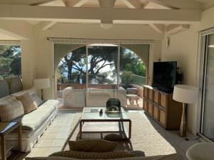 a living room with a couch and a table at VILLA LES PINS in Le Lavandou