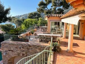 a house with a patio with a table and chairs at VILLA LES PINS in Le Lavandou