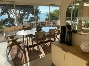 a kitchen with a table and chairs and a large window at VILLA LES PINS in Le Lavandou