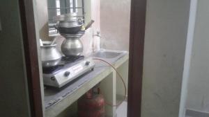a kitchen with a mixer on a counter next to a sink at Xavier Guest House in Chennai +38 photos