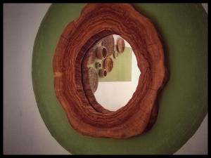 un espejo circular de madera con pisadas en una pared verde en La Casa di Clé, en Fasano