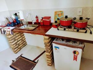 eine Küchentheke mit Töpfen und Pfannen auf einem Herd in der Unterkunft Vila Samin Moitas in Praia de Moitas
