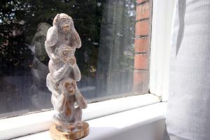 una estatua de un mono sentado en el alféizar de una ventana en Empire House by Tŷ SA en Newport