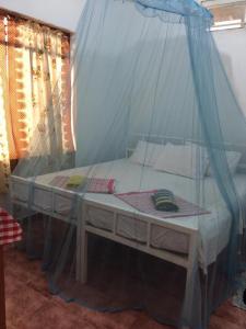 a bed with a mosquito net in a room at Guesthouse Kind and Love in Hikkaduwa