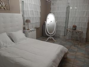 um quarto com uma cama branca e um espelho grande em Chambre d'hote Casa Tozza em Porticcio
