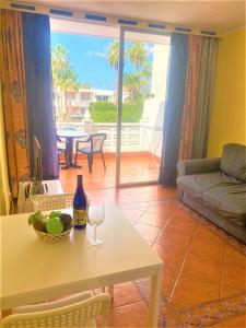 a living room with a table with a wine glass at Cozy one bedroom apartment with spacious terrace. Pool and garden view in Costa Del Silencio