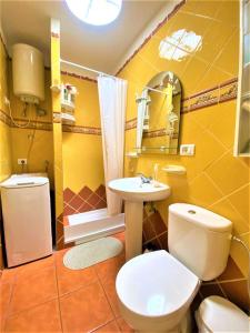 a yellow bathroom with a toilet and a sink at Cozy one bedroom apartment with spacious terrace. Pool and garden view in Costa Del Silencio