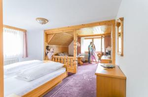ein Schlafzimmer mit 2 Betten und Personen, die in einem Zimmer stehen in der Unterkunft IMbery Hotel & Restaurant Hinterzarten in Hinterzarten