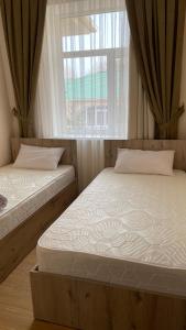 twee bedden in een kamer met een raam bij Apartment in Raduga West, Issyk-Kul in Tamchy