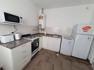 uma cozinha com electrodomésticos brancos e um micro-ondas em Casa Las Lengas em Ushuaia