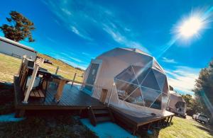 een koepeltent op een terras met de zon in de lucht bij Hillview Farmstay in Gundagai