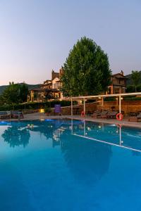 a large swimming pool with blue water at night at Nymfasia Resort in Vitina