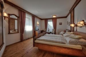 - une chambre avec un grand lit et un cadre en bois dans l'établissement Gräfliches Hotel Alte Post, à Bad Birnbach