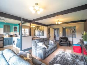 a living room with two couches and a kitchen at Trenewydd Farm Holiday Cottages in Cardigan