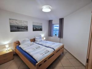 ホールマージールにあるNordseetraumのベッドルーム1室(青と白のシーツが備わるベッド1台付)