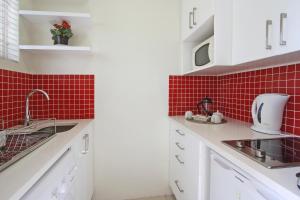 a kitchen with a sink and red tiles at Sandringham in Cape Town