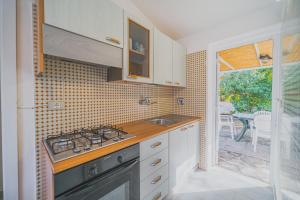 a kitchen with a stove and a sink and a window at Casa a 30 metri da Pareti in Capoliveri
