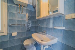 Un baño con azulejos azules, inodoro y lavabo. en Casa a 30 metri da Pareti, en Capoliveri 22 fotos más