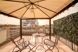 a table and chairs on a balcony with an umbrella at Aurelius Art Gallery Hotel in Rome