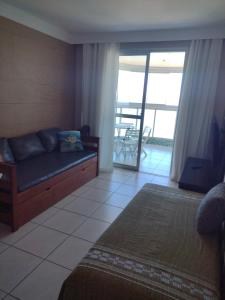 um quarto com um sofá e vista para uma varanda em D Frente Green D 2 em Vila Velha