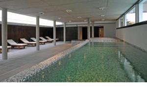 a large swimming pool in a building with chairs at Punta vacaciones -piscina solo en vacaciones y fines de semana largos- in Las Gaviotas