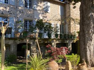 a building with a balcony with plants on it at Le Clos Rodolphe in Beaulieu-sur-Dordogne
