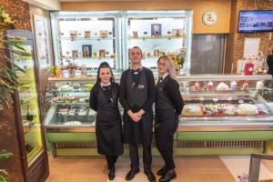 a group of three people standing in front of a shop at Hotel Dubrovnik in Zenica
