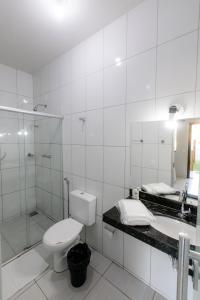 een badkamer met een toilet, een wastafel en een douche bij Pousada Pontal in Curvelo