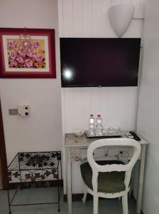 西爾米奧奈的住宿－Casa Patrizia B&B cir in info，一张带白色椅子的桌子和一张带电脑的桌子