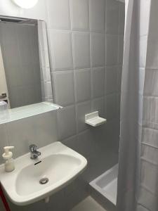 a white bathroom with a sink and a shower at Petska Apartments in Leptokaria +19 photos