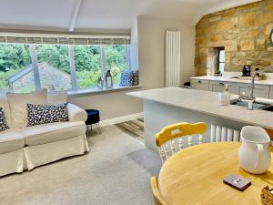 cocina y sala de estar con mesa y sofá en No. 3 Tomlinsons Apartments en Rothbury