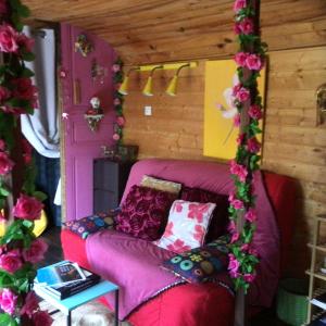 a living room with a couch in a room with flowers at Roulotte Fenouillet in Hyères