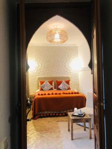 a bedroom with a large bed and a large mirror at Riad Dar Beldia and Spa in Marrakesh