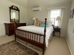 a bedroom with a bed with a dresser and a mirror at Bermuda At the Beach One-Bedroom in Paget Parish +20 photos
