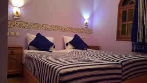 a bedroom with a large bed with blue pillows at Gite Talassemtane in Chefchaouen