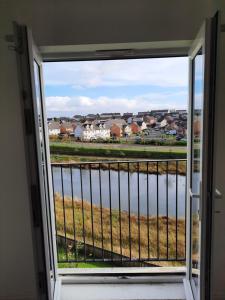 a window with a view of a body of water at Pond View Upper in Airdrie