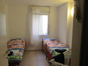 a small room with two beds and a window at Apartment Tal in the Judean Desert in Kfar Adumim