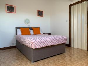 1 dormitorio con 1 cama con almohadas de color naranja en Manchester Stay Hotel, en Mánchester