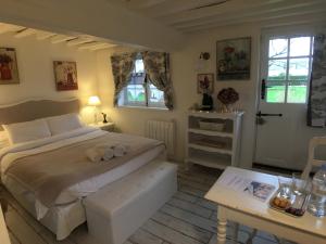 a bedroom with a large bed and a table at La Romance et la Romanesque in Berville-sur-Mer