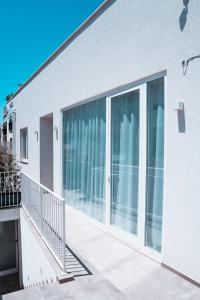 einen Balkon mit Glasschiebetüren auf einem Gebäude in der Unterkunft SIGNORA ANGELINA in Polignano a Mare