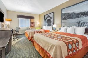 a hotel room with two beds and a flat screen tv at Super 8 by Wyndham Kokomo in Kokomo +51 photos