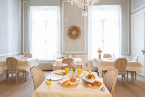 a dining room with tables and chairs with food on them at Guesthouse Mirabel in Bruges