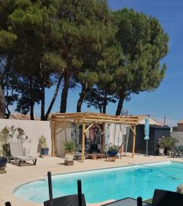 een zwembad met een tuinhuisje en een zonneterras bij Majopau in Boujan-sur-Libron