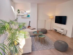 a living room with a couch and a tv at Dunes et Mer - Terrace, garden and free parking space in Ostend