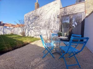 - deux chaises bleues et une table sur une terrasse dans l'établissement Dunes et Mer - Terrace, garden and free parking space, à Ostende