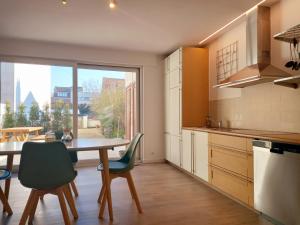 a kitchen with a table and chairs and a large window at Dunes et Mer - Terrace, garden and free parking space in Ostend