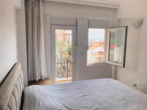 a bedroom with a bed and a large window at Heybe Apart in Kaş
