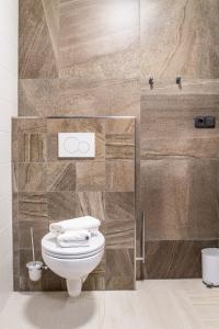 a bathroom with a toilet and a stone wall at Chata Krušnohorka in Kovářská +80 photos