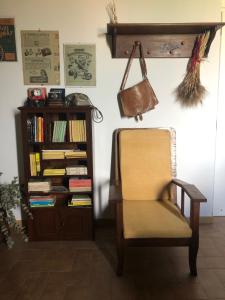 a chair and a book shelf with books at Tenute Pacelli - Azienda Agricola in Malvito