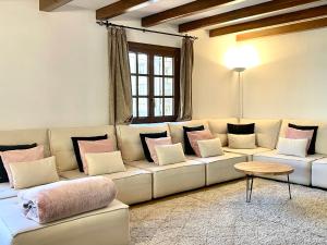 uma sala de estar com um grande sofá branco com almofadas em Xalet Kotki HUT1-005472 em Canillo